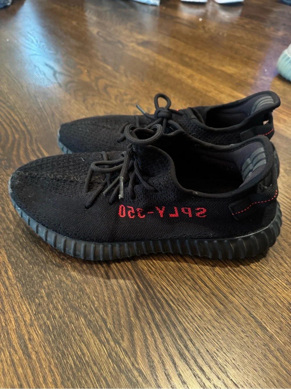 Black Yeezy 350 sneakers with red text